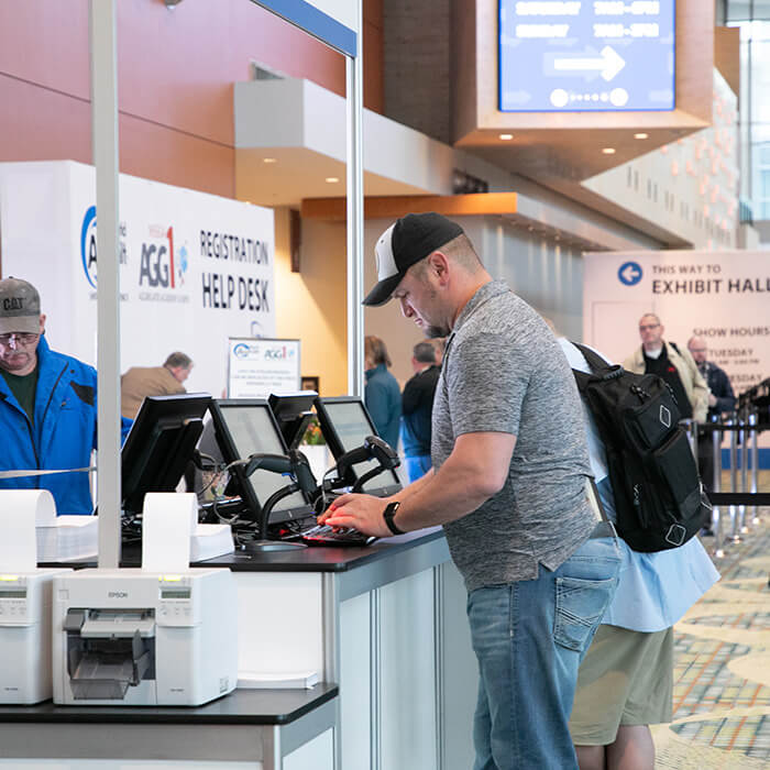 Guy registering at the world of asphalt desk