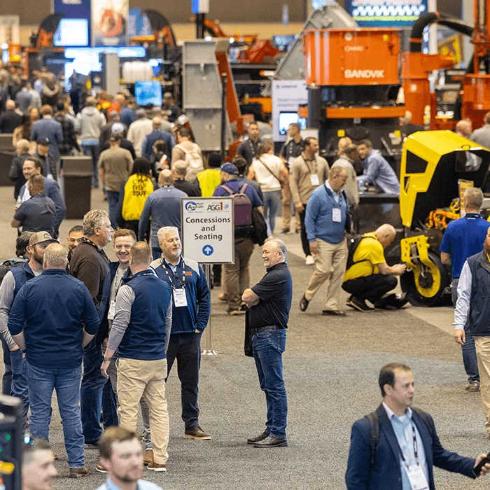 Walkway at World of Asphalt 2022 with a lot of people and exhibits in the back of Caterpillar, Kenco and Volvo